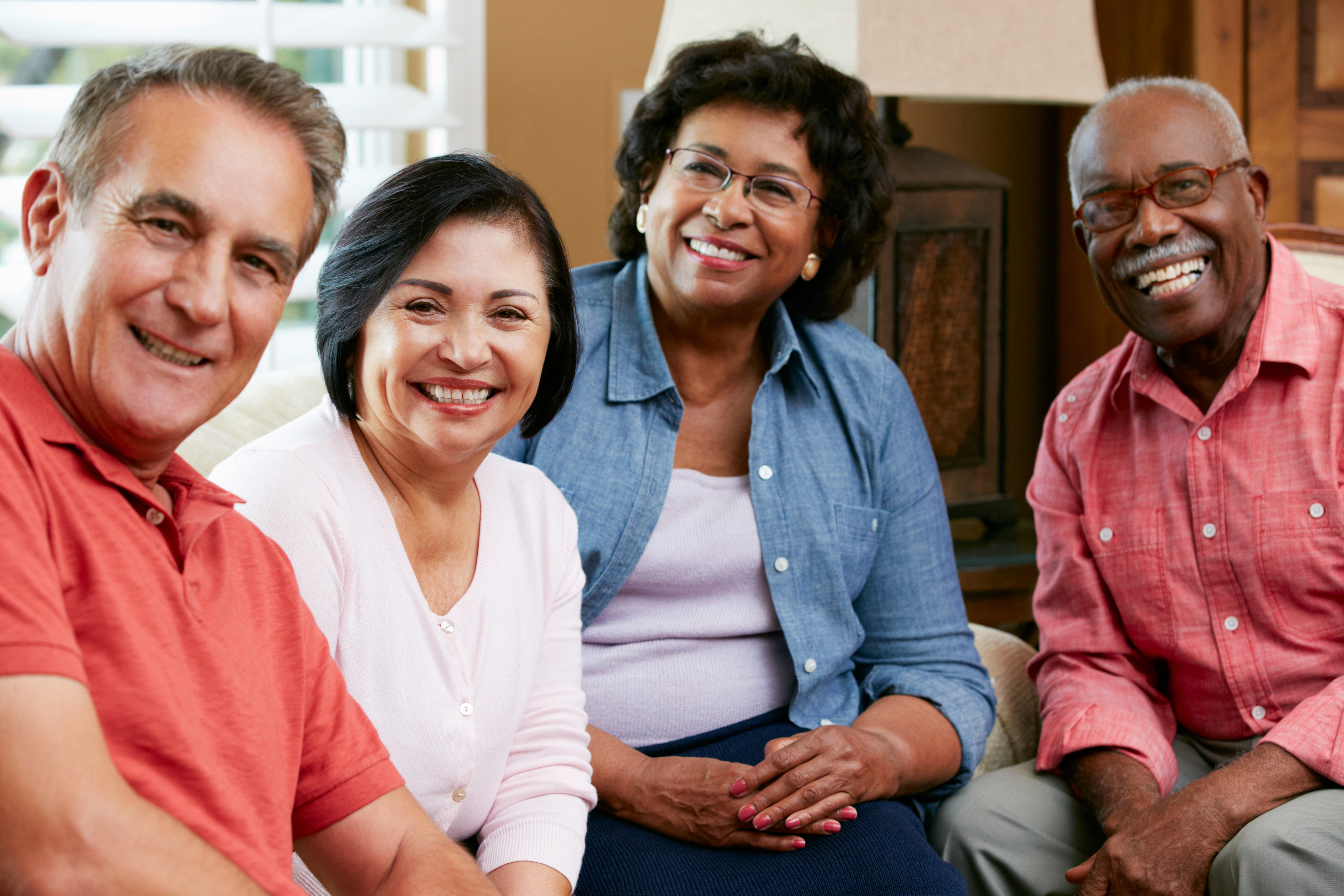 a group of people smiling while sitting on a couch