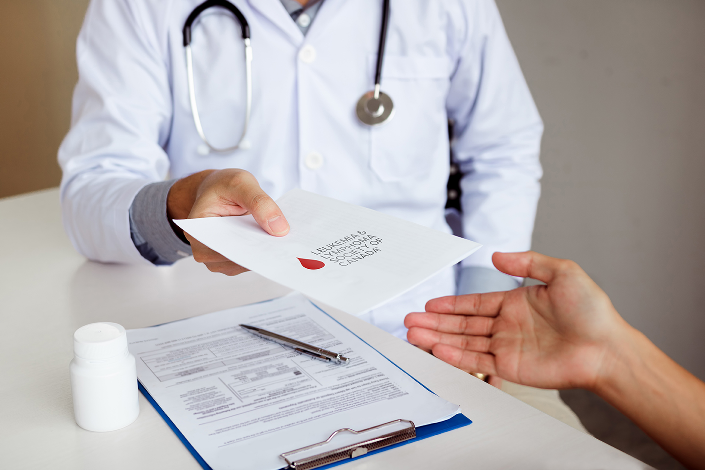 A doctor handing out a piece of paper with the LLSC logo on it.