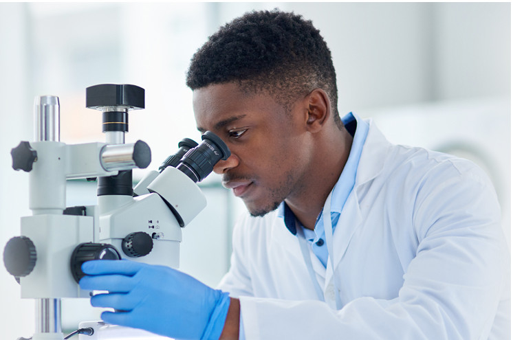 Scientist viewing his microscope.