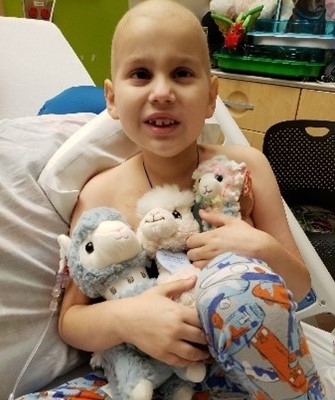 Ollie in hospital bed with toys