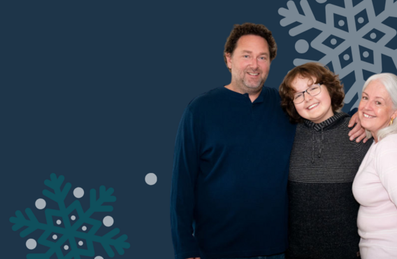 A family of three (Mother, Father, and son) hugging and smiling with snowflakes in the background