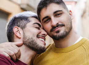 Two men hugging and smiling