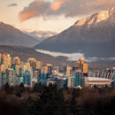An evening landscape shot of the city of Vancouver with mountains in the background.